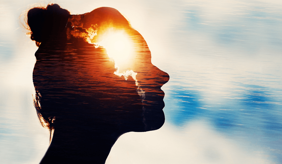 A woman's profile in front of a bright blue sky. In her mind the sun rises above the cloud.