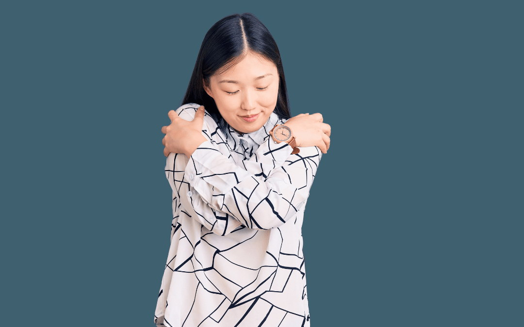 A woman hugging herself.