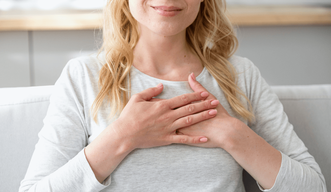 Woman holding both hands to her heart, feeling every emotion.