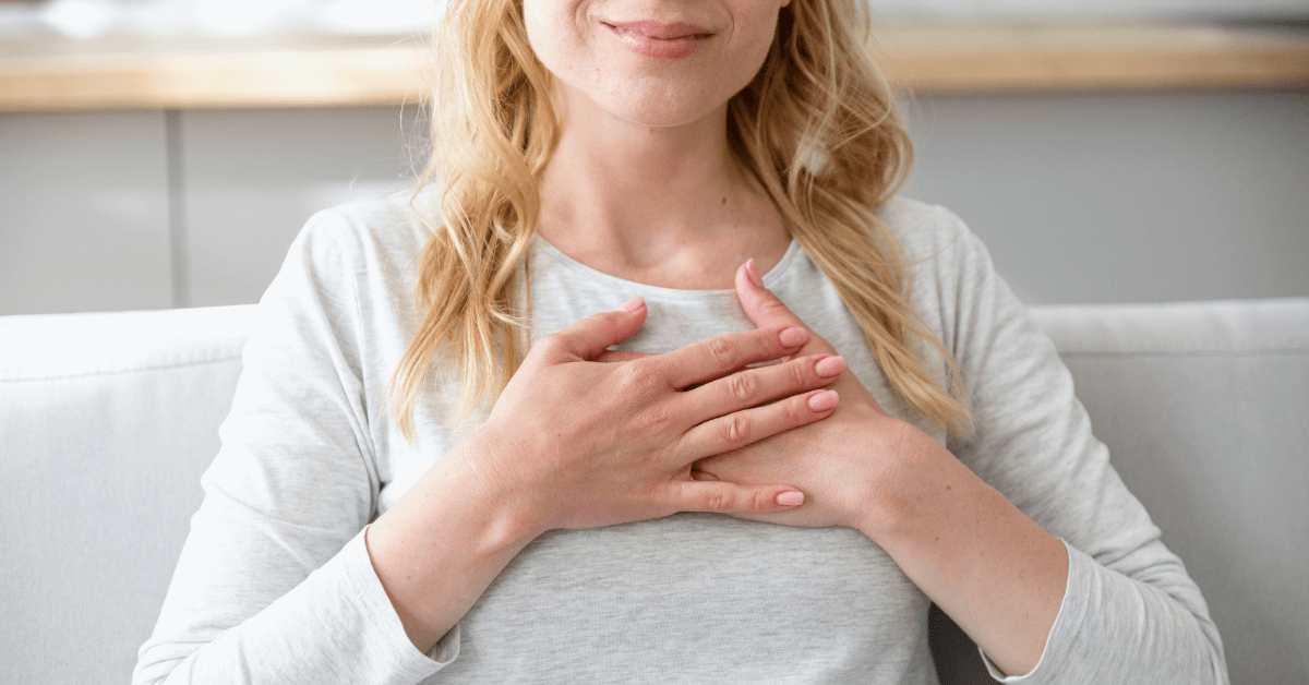 Woman holding both hands to her heart, feeling every emotion.