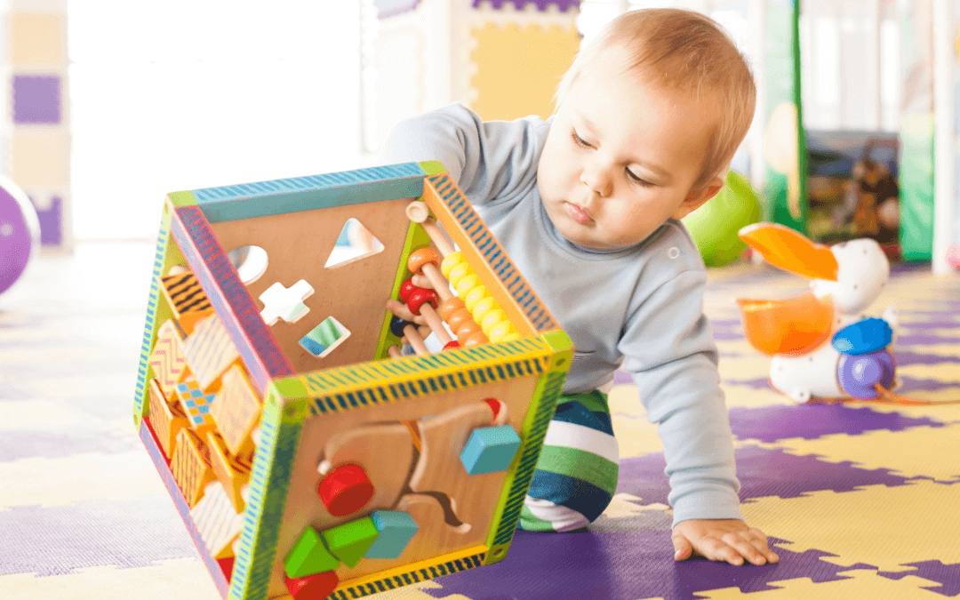 A toddler topples over his toy to see what will happen.