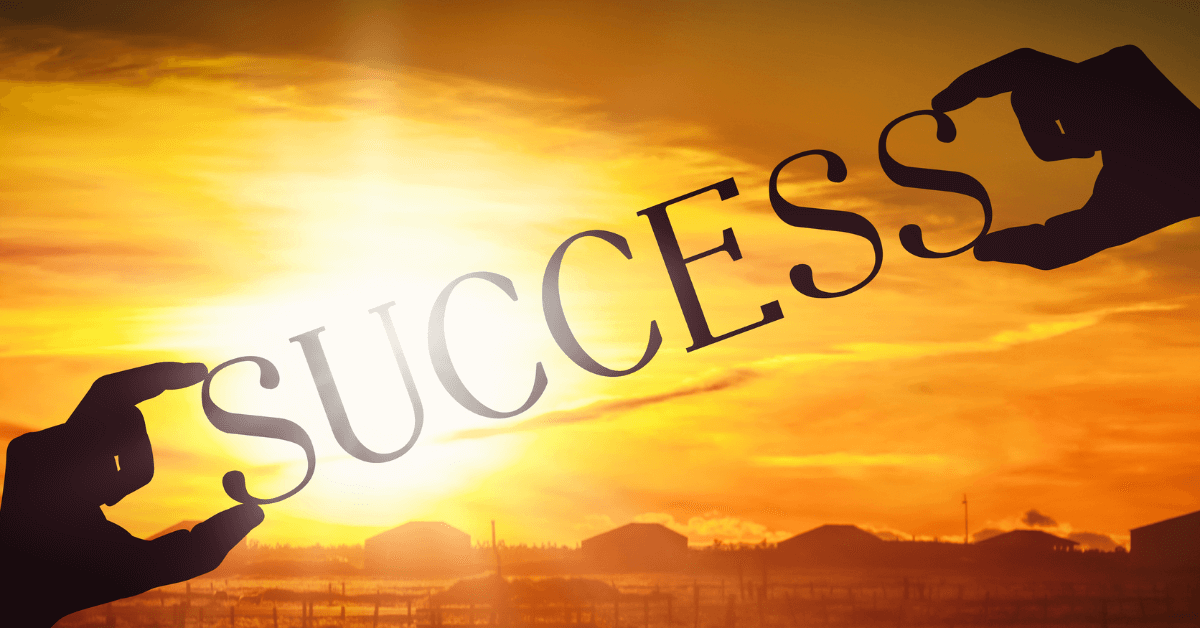 The word success in front of a beautiful sunrise.