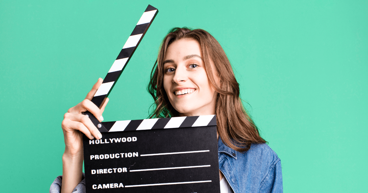 Woman holding up a clapperboard about to say action.