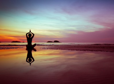 Woman doing Yoga at the beach.